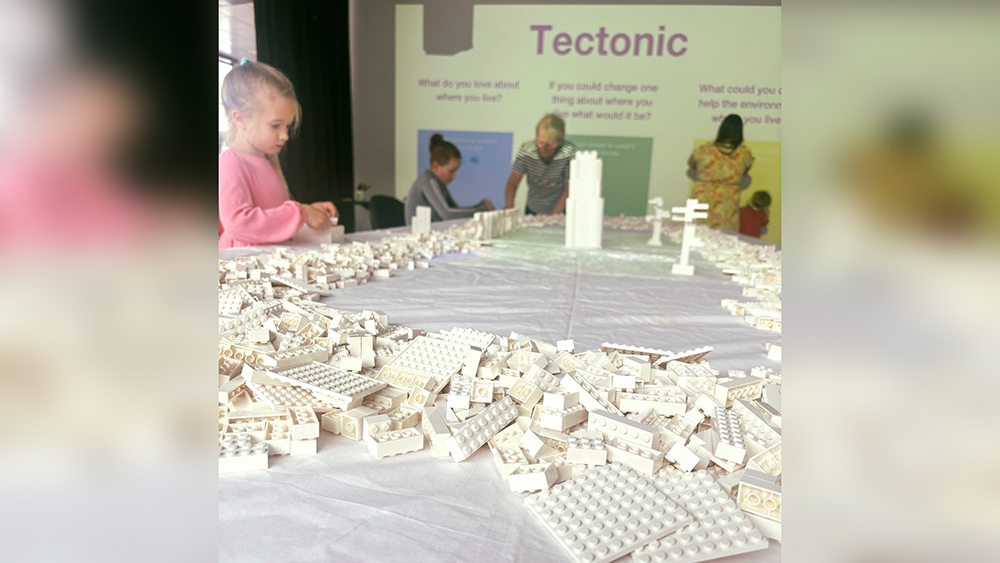 A Tectonic event featuring children building a cityscape with help from adults at 1000px wide.