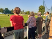 Spectators watching a cricket game.