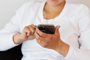 A woman sitting whilst using her mobile phone.