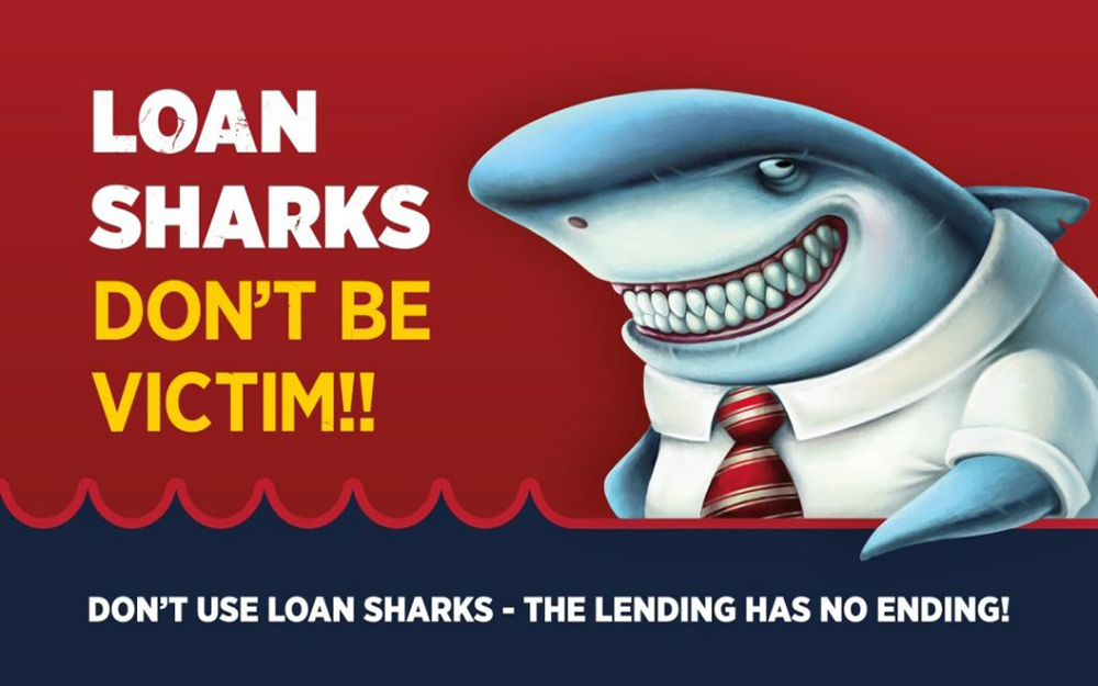 A grinning cartoon shark wearing a shirt and tie, captioned: 'Loan sharks, don't be a victim!!'.