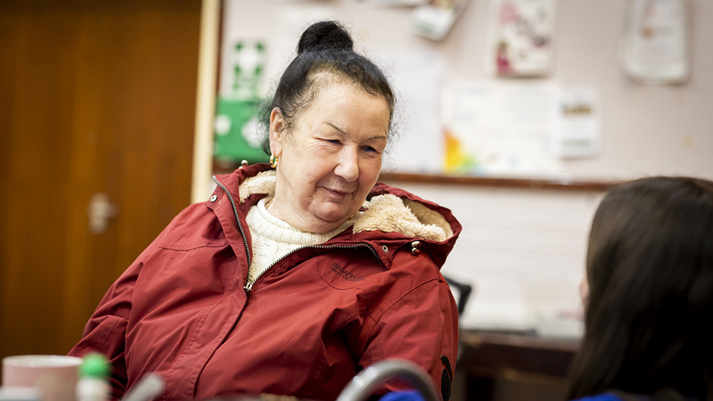Woman in red coat smiles.