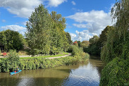 A beautiful sunny day view of the river Tone near Taunton, with flourishing trees on the bankside.