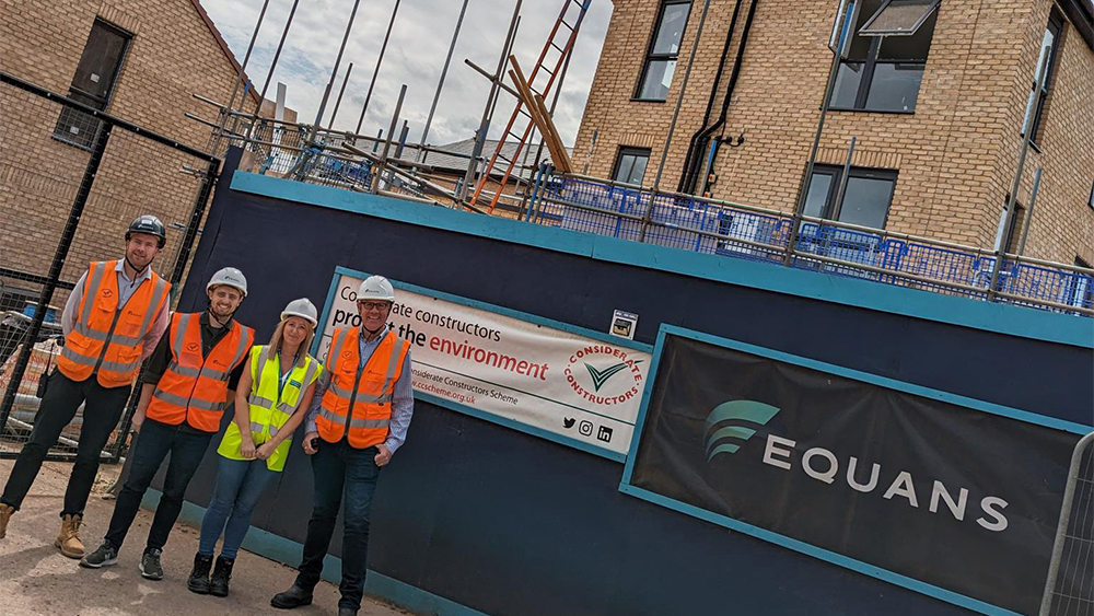 Group of Equans construction workers and a council officer standing in front of part of the newly constructed North Taunton Woolaway project.