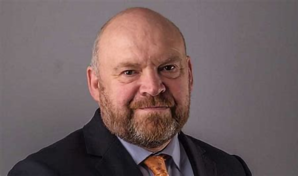 Professional portrait of Cllr Bill Revans wearing a suit.