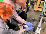 Beth and Annabel from Yeovil's special needs day-care centre learning bike repair techniques at Prodigal Bikes, Crewkerne.