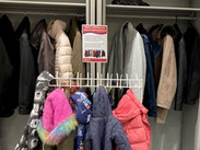 Rail of donated coats in a library.