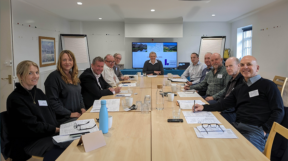 A group of Somerset Council's Business Mentors smiling at the camera whilst sat at a table.