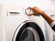 A woman's hand setting a program on an energy efficient washing machine.