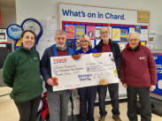 Staff from Chard Reservoir receiving their check from a representative at Tesco's in Chard.