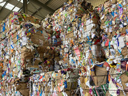 Bales of cardboard stacked high at a Material Recovery Facility.
