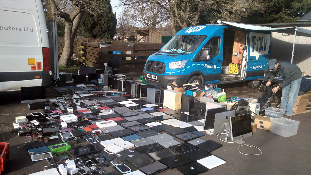 Donated tech laid out in rows in front of the Fixy van.