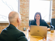 A Somerset Council Business Mentor with her laptop mentoring a business mentee in an office.