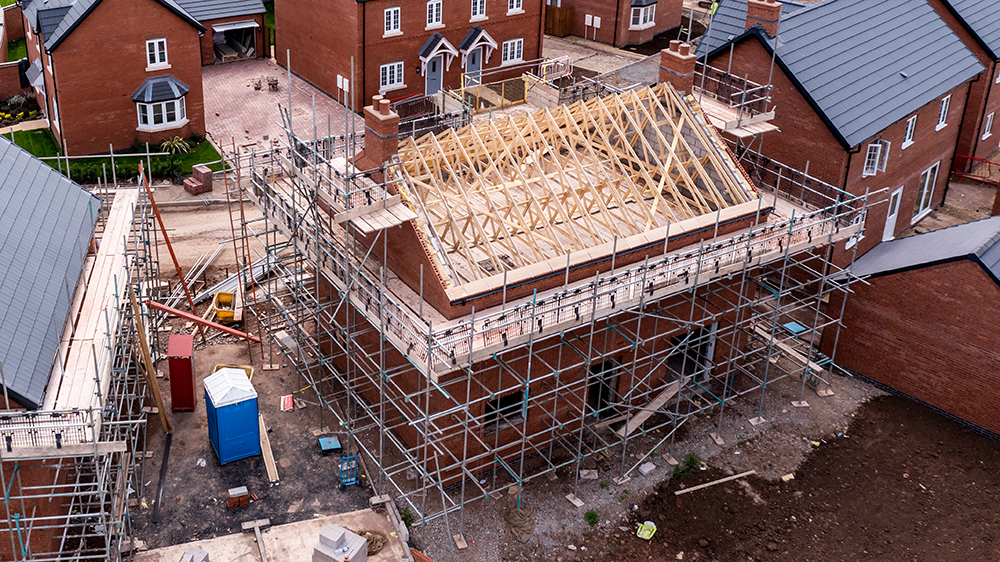 An aerial view of new build homes on a new housing estate with the roof exposed.