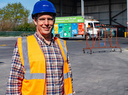 Councillor Richard Wilkins wearing a hard hat whilst posing for the camera at a reycling depot.
