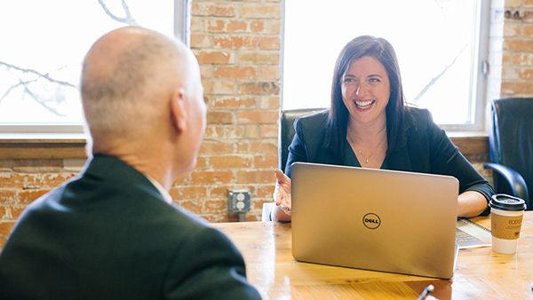 A Somerset Council Business Mentor with her laptop mentoring a business mentee in an office.