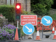 Roadworks with temporary traffic lights in rural village.