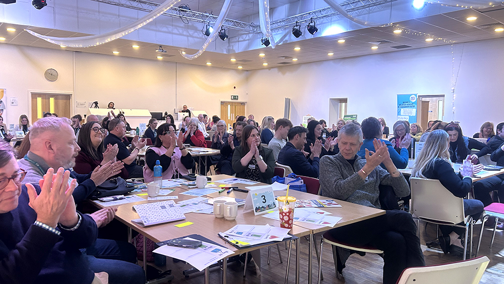 Attendees clapping whilst sat at tables at the “Celebrating Care Leavers – Making a Difference Together” conference in Bridgwater.