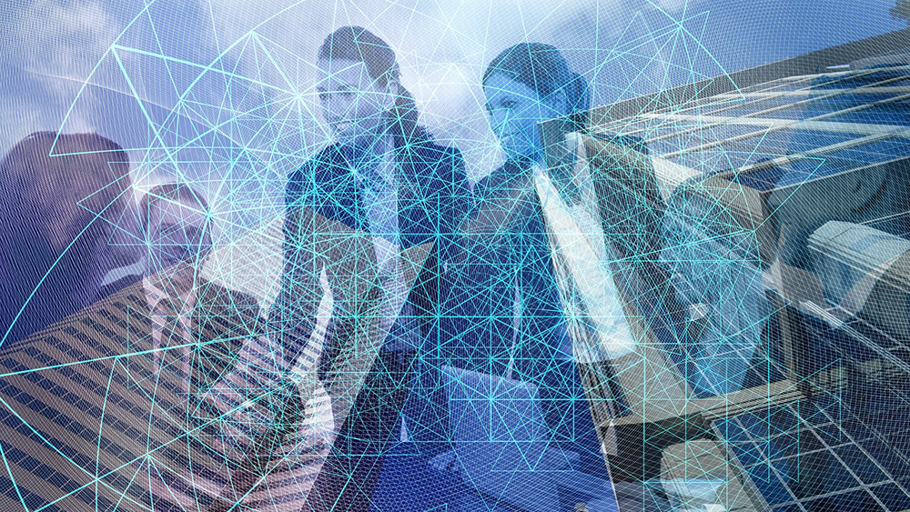 2 business people walk through a cityscape overlaid with blue digital lines, with tall buildings and glass reflections.
