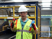 Councillor Richard Wilkins shows gas canisters removed from a conveyor belt at a recycling site.