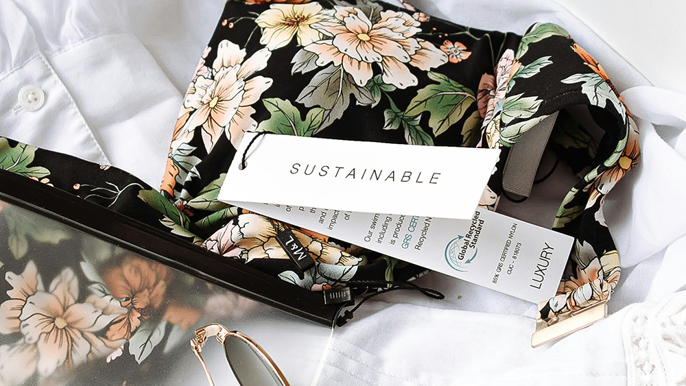 Stock image of a floral-patterned bag with 'Sustainable' tag, white shirt & sunglasses by Harper Sunday from Unsplash.