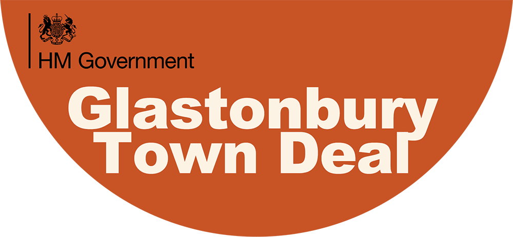 HM Government logo and “Glastonbury Town Deal” text displayed on an orange background.