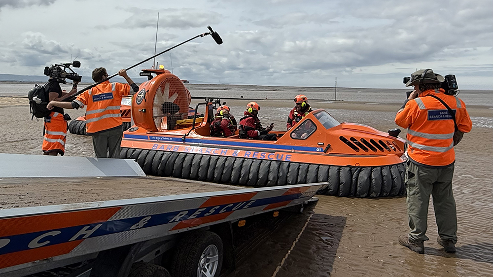 TV crew films BARB Search & Rescue team on an orange hovercraft at the Somerset coast.