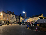 Nighttime film set in Axbridge with crew, light crane and Somerset Council van for local film and TV production initiative.