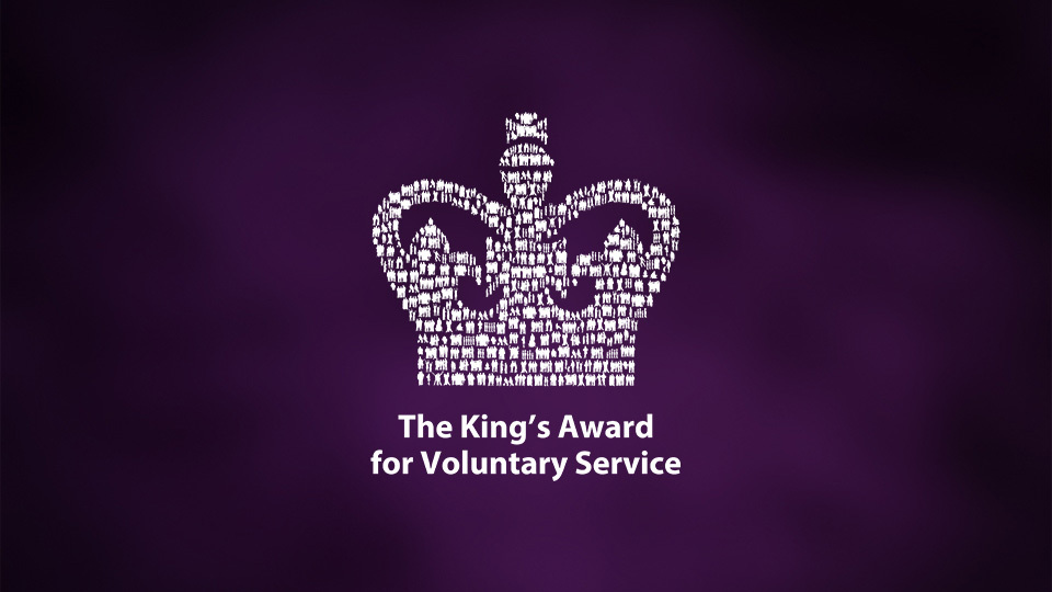 The King's Award for Voluntary Service logo with a crown of human figures on a purple background.