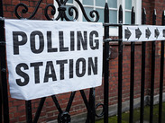 Sign attached to a fence showing polling station.