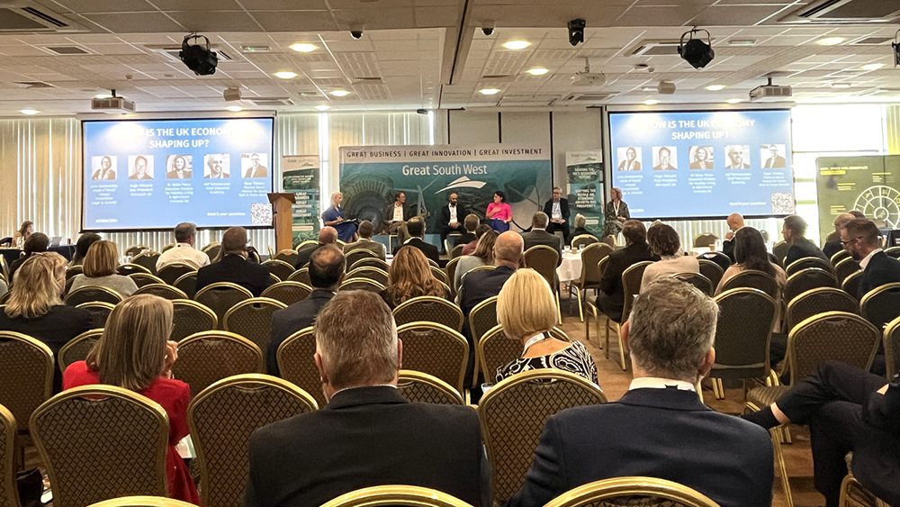 The Great South West Annual Conference with attendees watching a panel on UK economy and regional innovation.