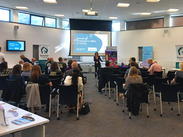 Invest Somerset Showcase 2025 Supporting SMEs and VCSEs event in Shepton Mallet. Attendees seated facing a presentation screen.