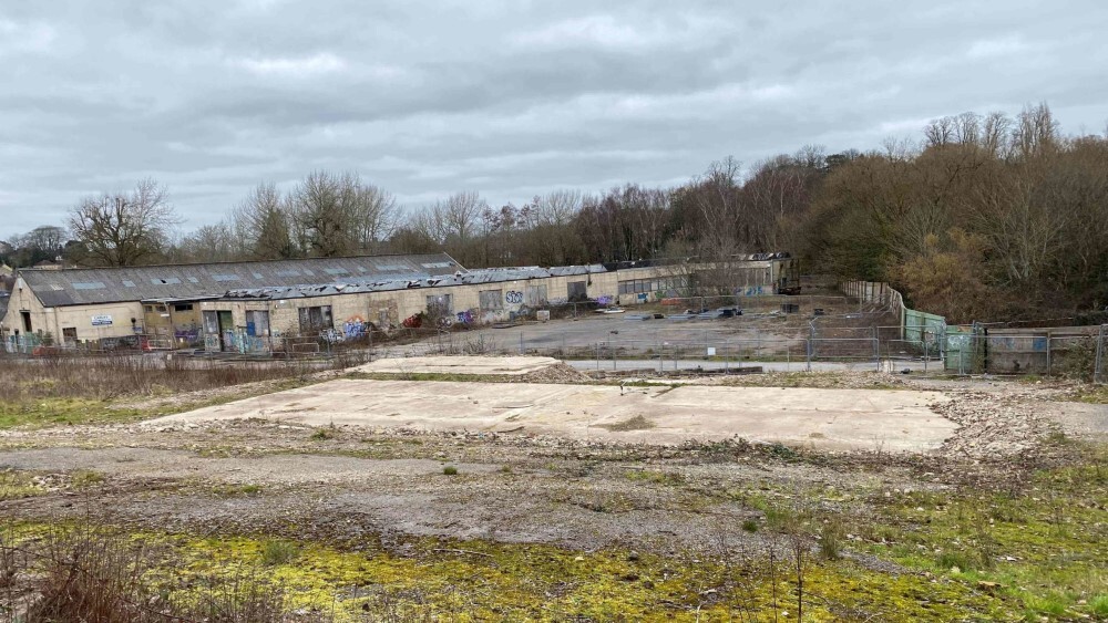 The disused Saxonvale site in Frome, showing derelict warehouses, graffiti, and overgrown vegetation ahead of redevelopment.