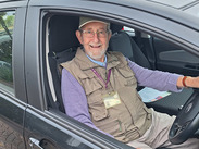 Volunteer driver, Paul Keeble, sat in his car smiling.