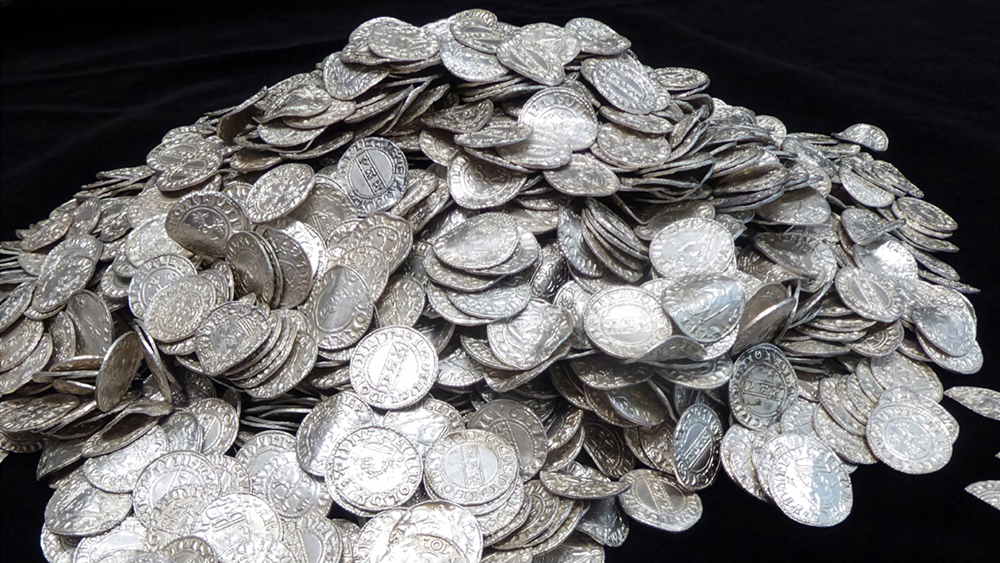 Pile of medieval silver coins from the Chew Valley Hoard displayed on a black background.