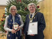 Christine Alderman and Somerset Council Chair, Cllr Mike Best holding a plaque and certificate.