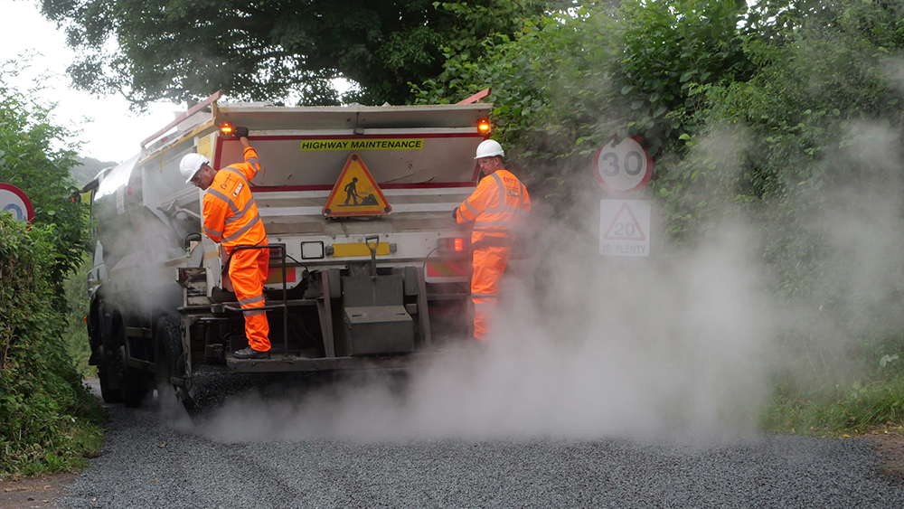 A team of Highway Maintenance workers surface dressing a Somerset road.