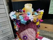 Decorative Holocaust Memorial candle surrounded by colourful handmade flowers and remembrance messages on display at Taunton Library.