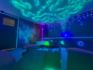 A calming sensory room with glowing cloud ceiling, soft lighting, ball pits and tactile features designed to support wellbeing.