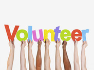 Hands holding letters spelling out volunteer.