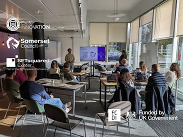 Workshop session with seated attendees, presenter speaking at front & Somerset Council, Exeter Innovation and SETsquared branding visible.