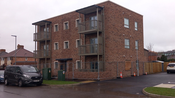 Lavinia House new eco homes on Roman Road, Taunton, showing a modern brick apartment building and houses ready for handover.