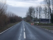 A361 reopened to traffic after floodwater receded, showing a clear road surface with cones marking the roadside following recent flooding.