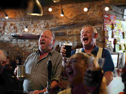 Mark Addy (left) and Martin Clunes (right) filming Mother’s Pride inside a historic Somerset pub, raising pints at the bar.