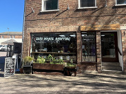 Exterior of Lesser Litter in Taunton, a refill and reuse shop opposite the library, with zero‑waste window signage and planters outside.