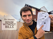 Guy Martin outside a home holding an energy bill beside the House Without Bills logo, illustrating heat pumps and cutting heating costs.