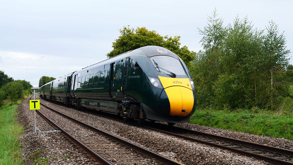 GWR Intercity Train through Rural Countryside running on tracks, green fields and trees beside the line in Somerset.