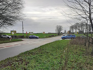 Rural road junction with vehicles and traffic signs at Whitnell Corner junction near West Horrington in Somerset.