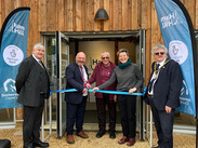 Ribbon cutting outside the new Ham Hill Visitor Centre, with people gathered between Somerset Council and Ham Hill banners at the entrance.