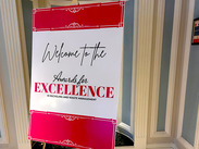 Sign welcoming guests to the Awards for Excellence in recycling and waste management displayed inside venue entrance.