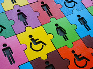 Colourful interlocking jigsaw puzzle pieces featuring human figures, symbolising diversity, inclusion and accessibility.